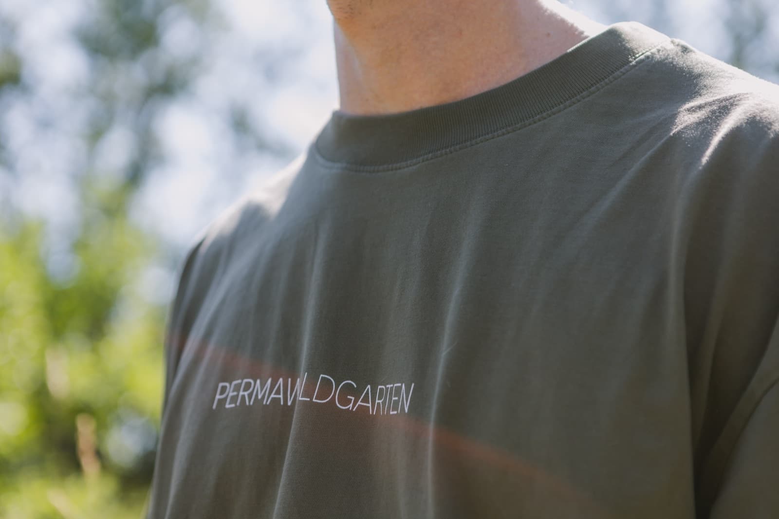 Nahaufnahme des PermaWaldGarten-Schriftzugs auf einem T-Shirt